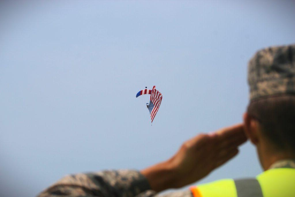 Officer saluting American flag in the sky